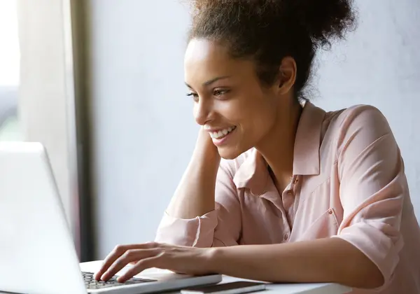 Young casual black woman at computer